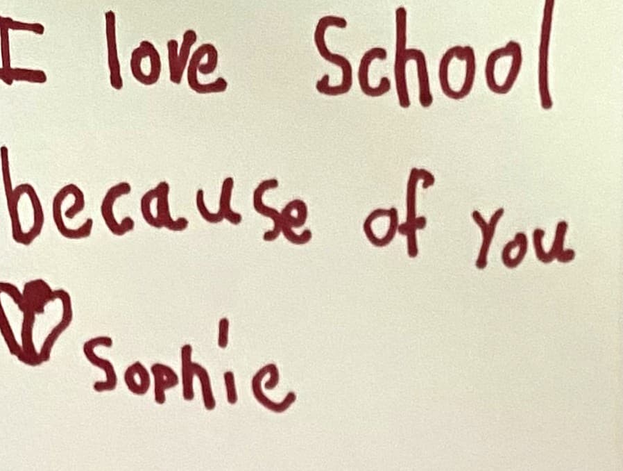 Handwritten note from a student that reads: I love school because of you. Love, Sophie